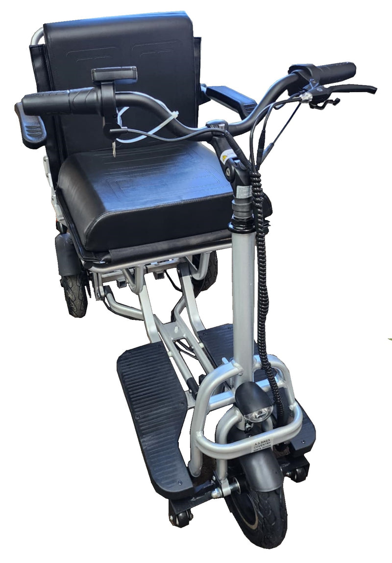 The folding mobility scooter from behind and to one side, showing the seat back and the handlebar column